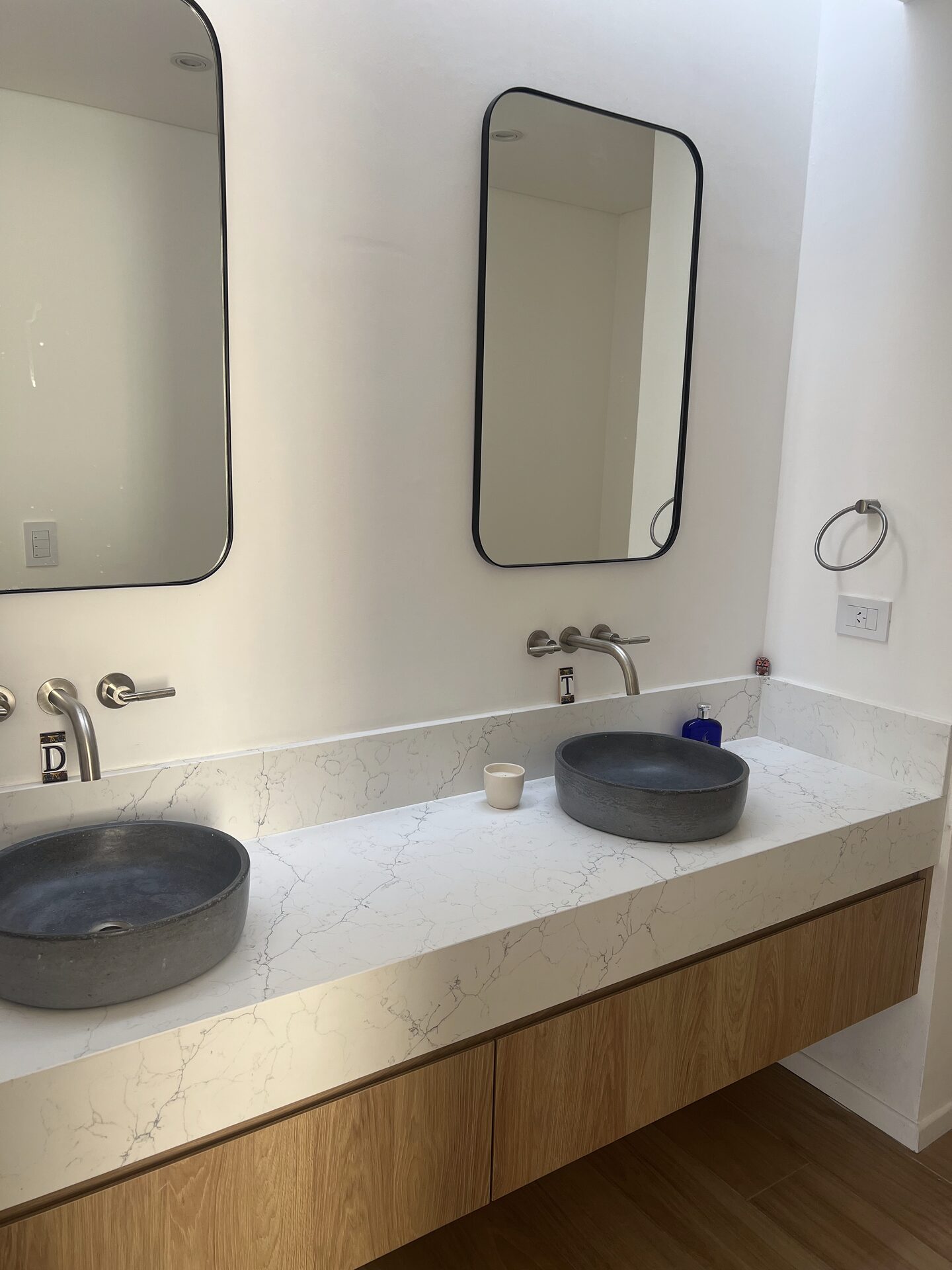 Baño con revestimiento de mármol gris y mesada integrada